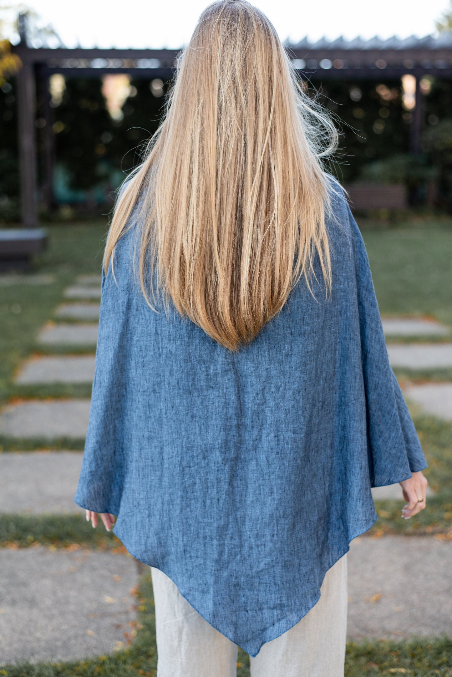 Rear view of the linen poncho, highlighting its flow and design.