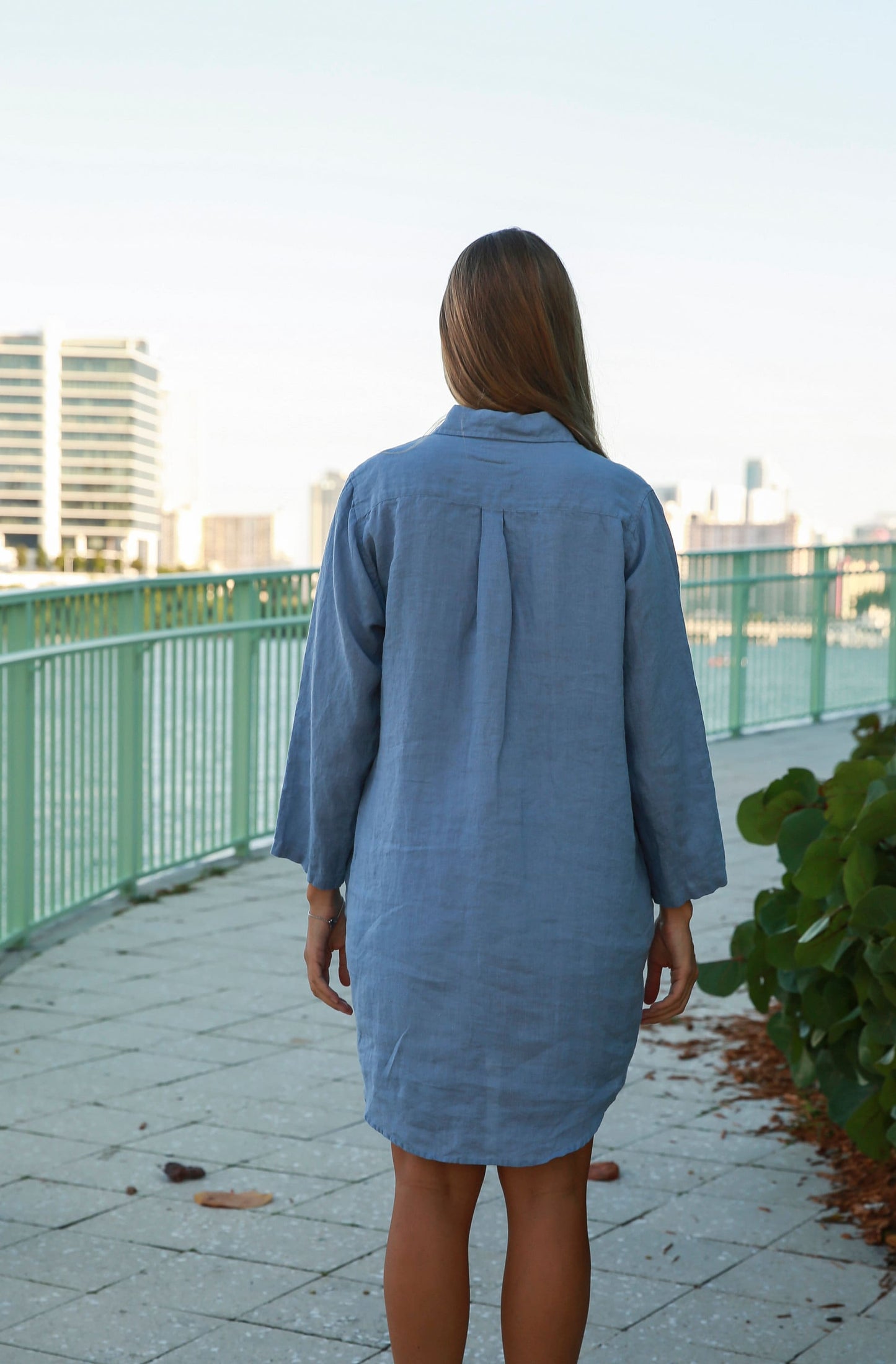 Back view of the long linen shirt, emphasizing its length and elegance.