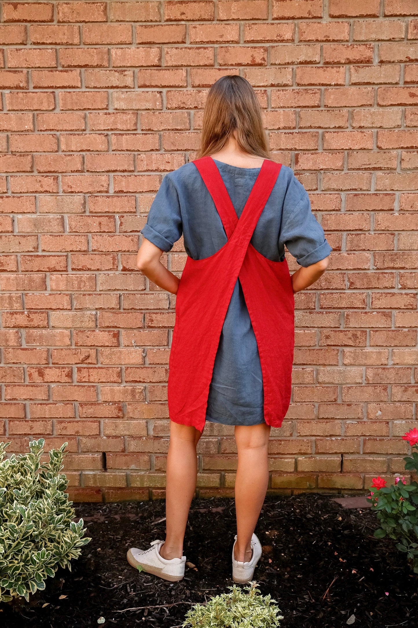 Person wearing a red linen apron, ready for festive kitchen activities