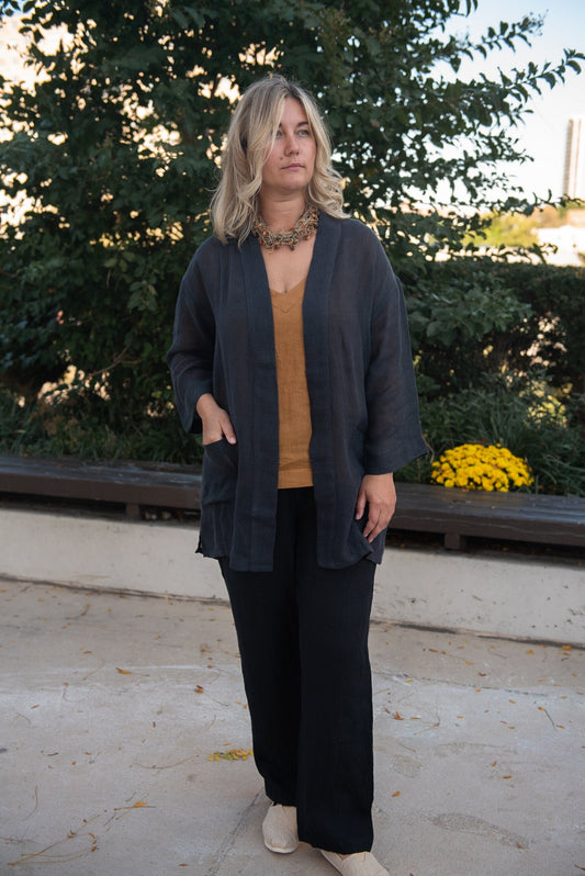 Woman in a cozy setting wearing an oversized boho linen cardigan with pockets