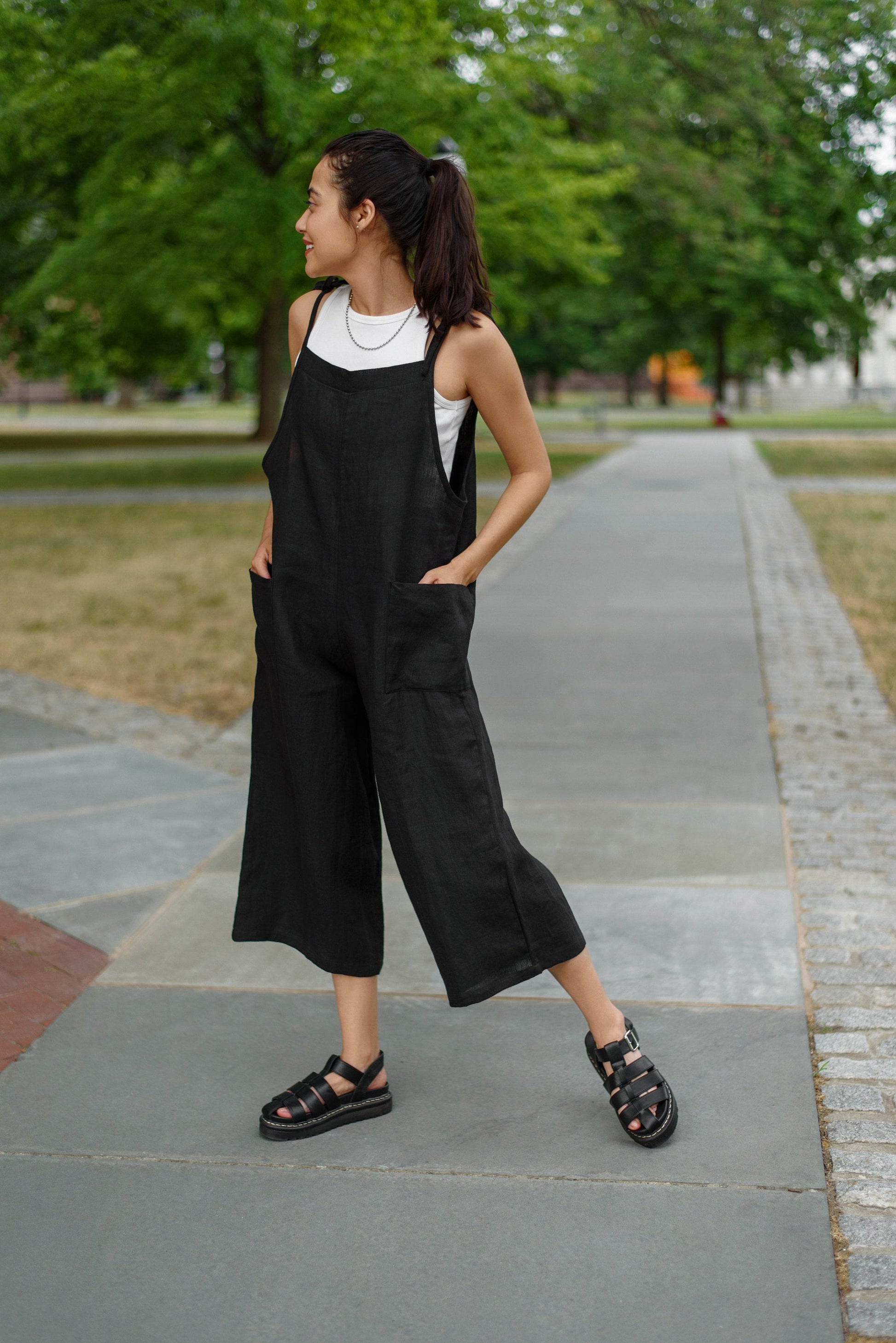 Side view of the linen overall romper, capturing its adjustable tie straps.