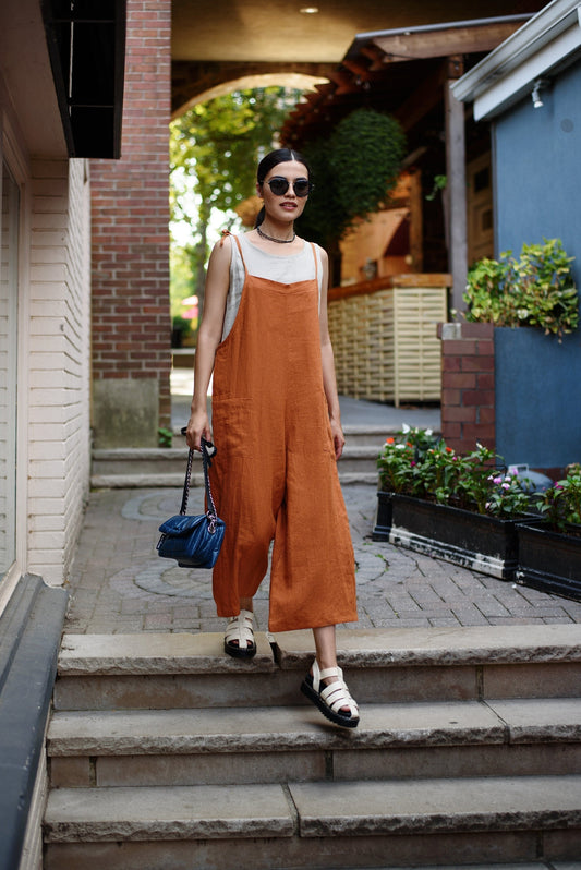 Woman in the linen romper, front view, highlighting its relaxed fit.