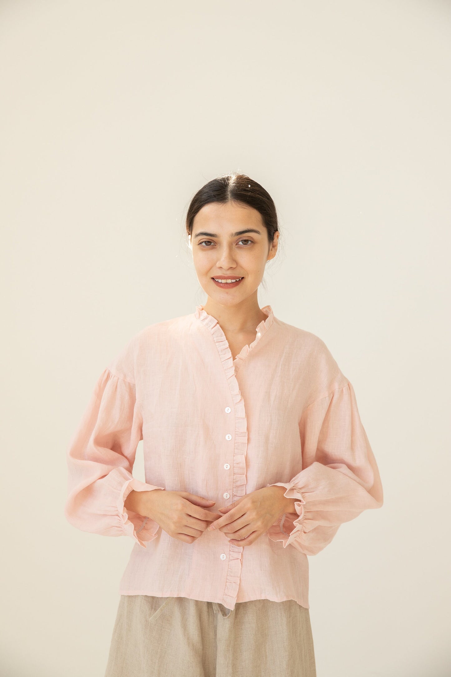 Woman showcasing the Linen Ruffle Blouse's versatile style for summer.