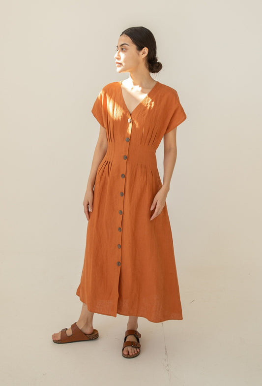 Elegant woman in a rust-colored Linen Charlotte Long Dress.