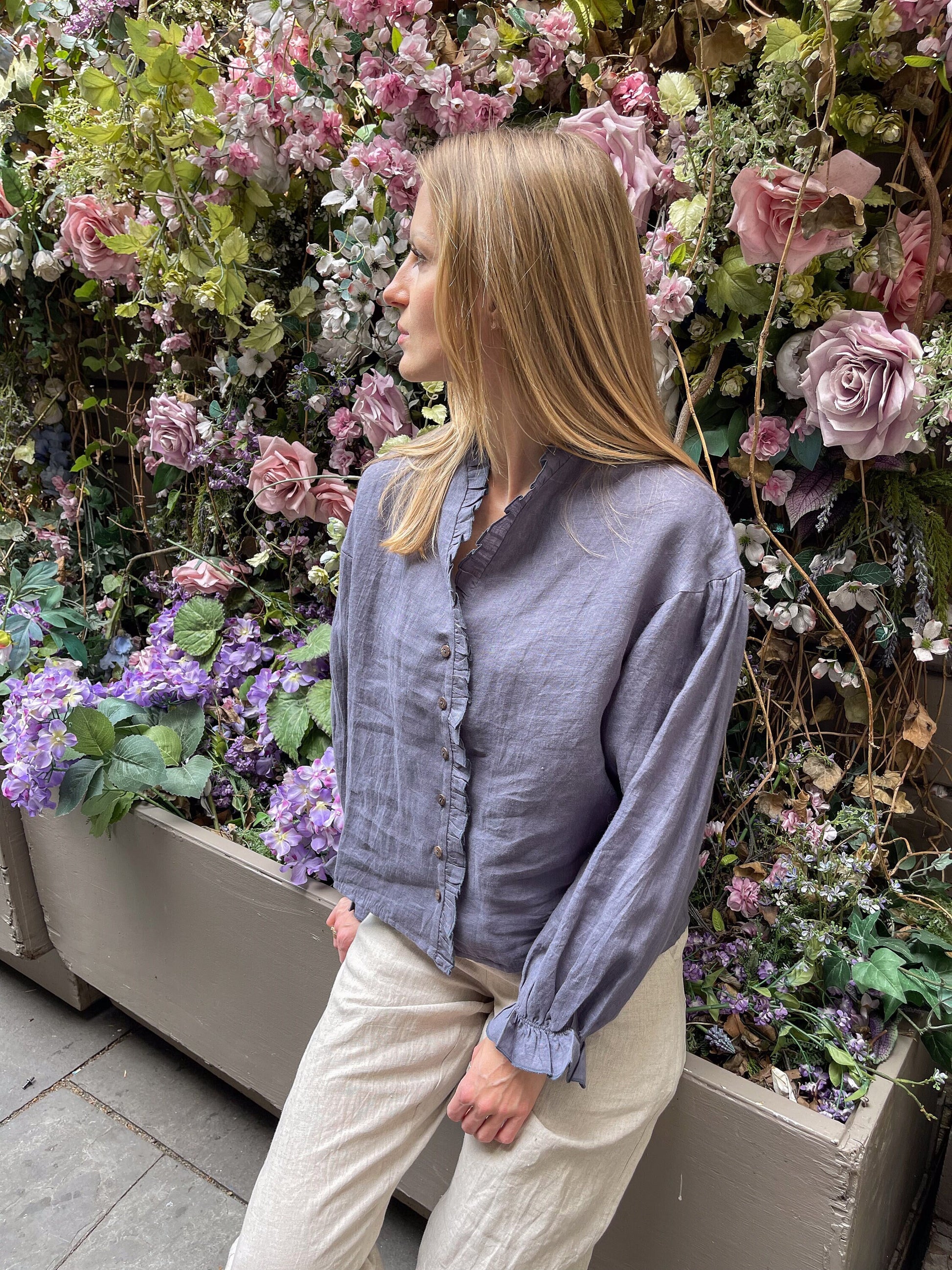 Woman enjoying the relaxed fit of the Linen Ruffle Blouse.