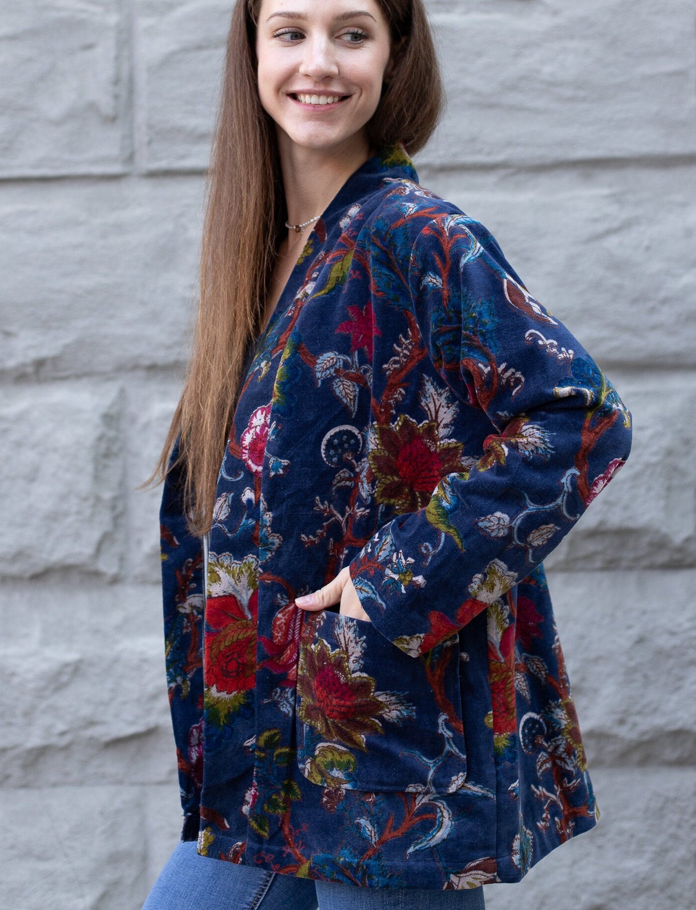 Graceful model, with hand in pocket, displaying the side profile of the Japanese-Inspired Velvet Kimono Cardigan with Bird Print Short Jacket.
