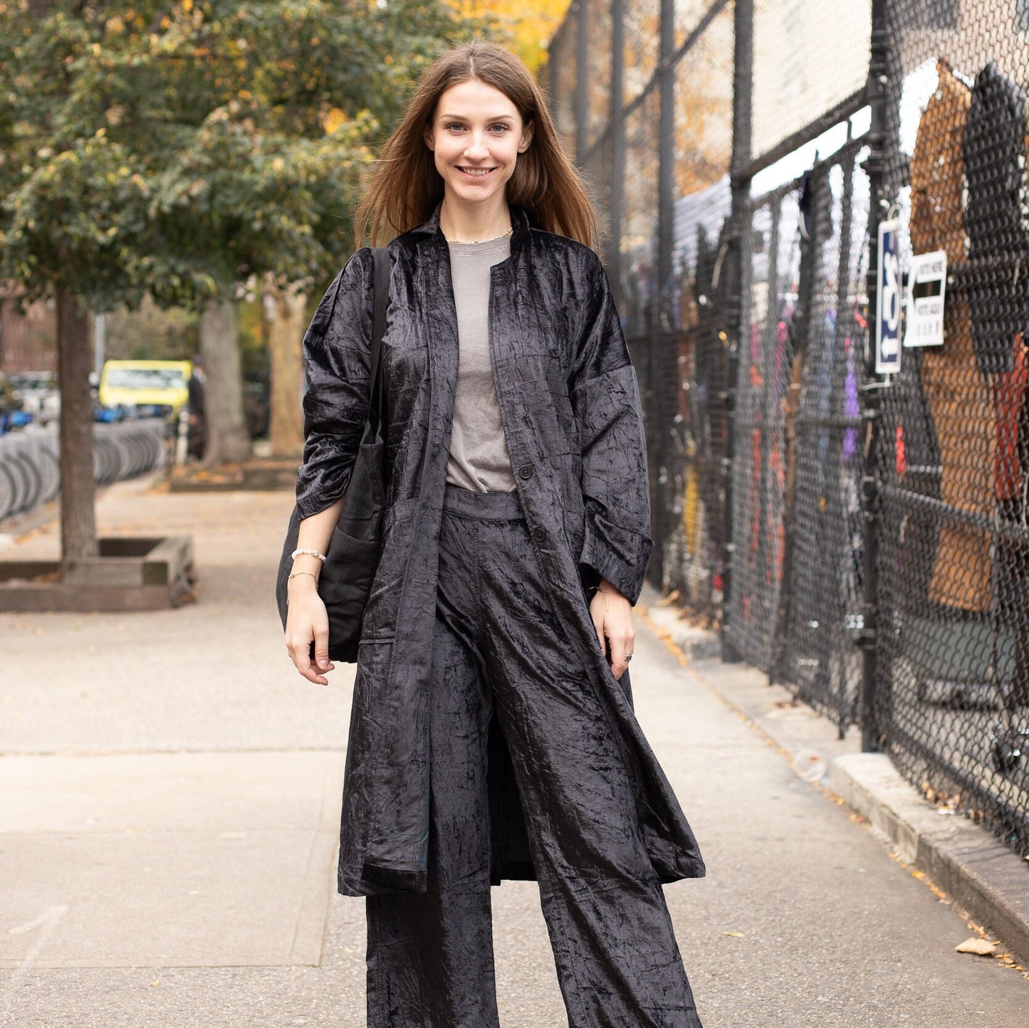 Young woman standing confidently, elegantly showcasing the Black Velvet Long Duster Jacket - Stylish Fall Coat and Velvet Cardigan for Women.