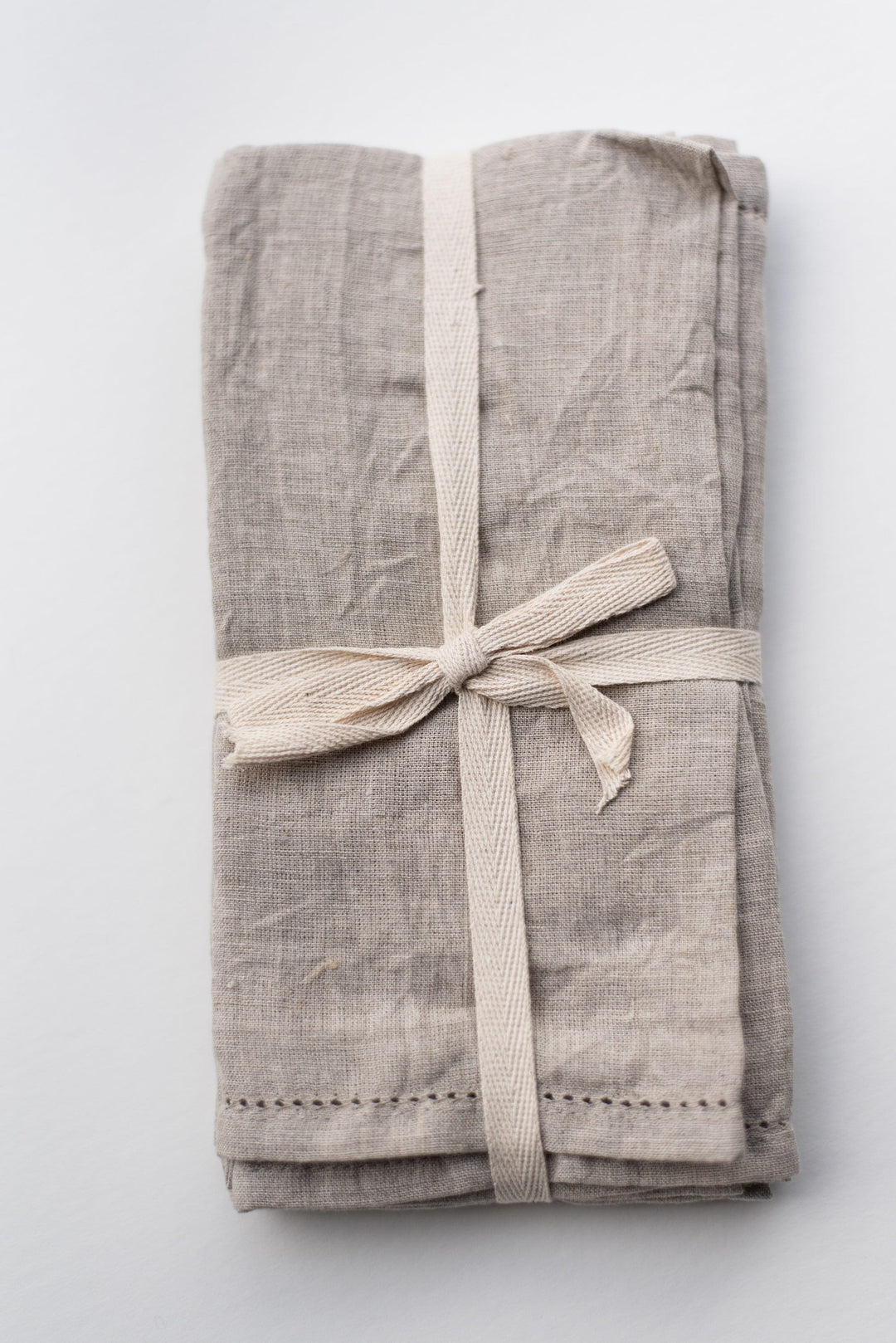 Close-up of the delicate hemstitch detailing on the linen napkins.