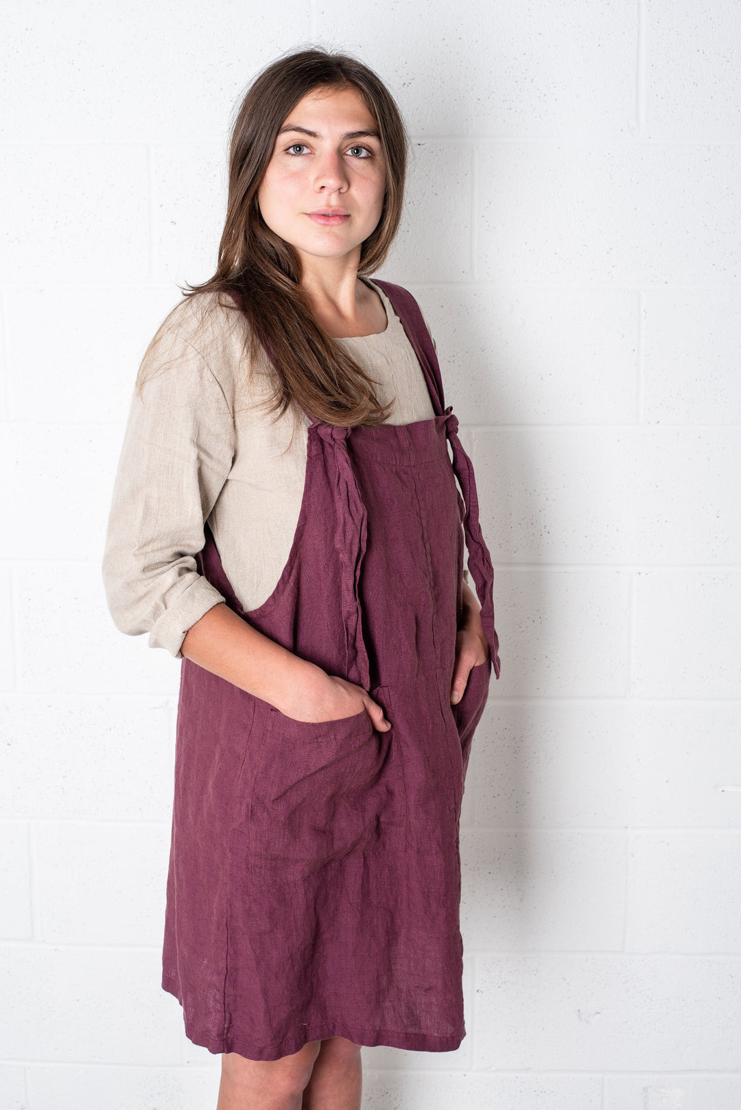 Woman wearing a classic linen garden dress, radiating rustic charm.