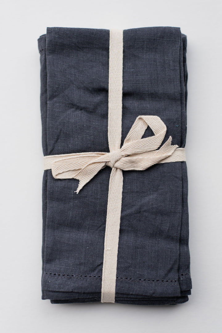 Perfect for any setting: A set of stonewashed linen napkins on a wooden table.