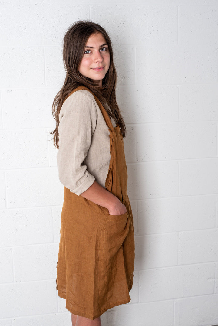 Detailed view of a French linen apron dress showcasing its natural texture.