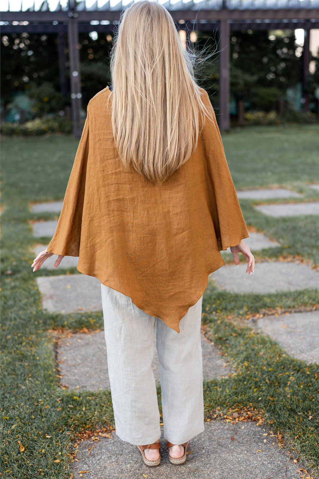 Full-length shot of a woman in the poncho, emphasizing its one-size-fits-all design.