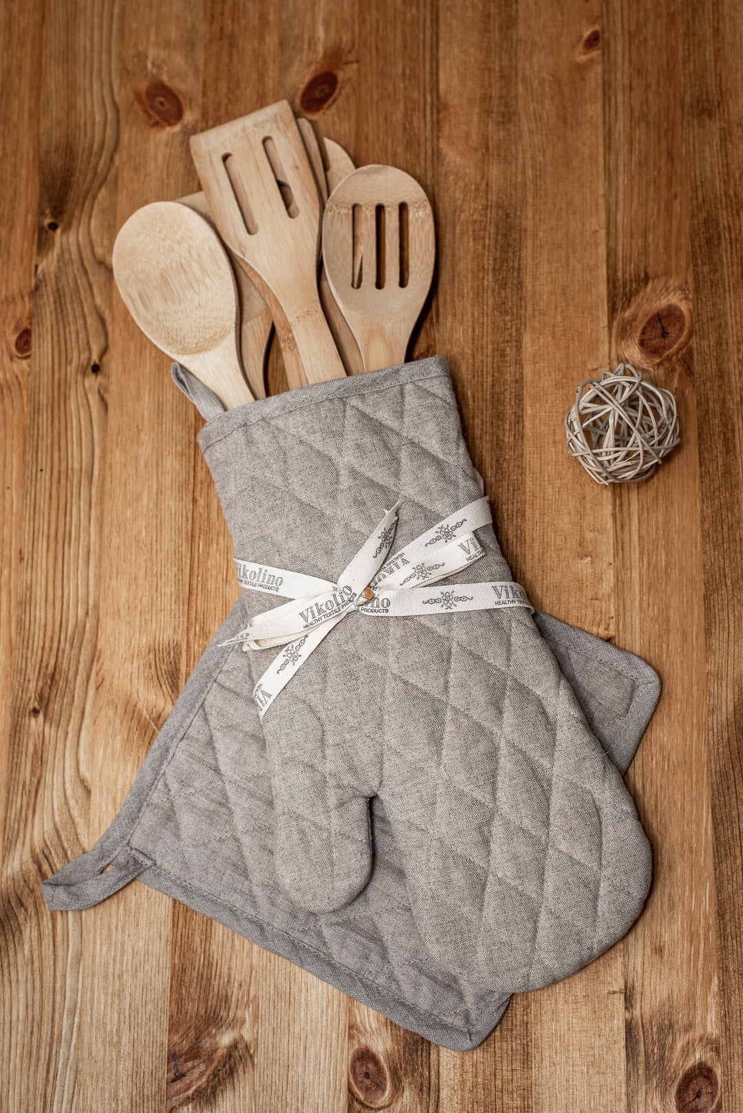 Woman confidently handling hot pans with linen oven mitt from the set.