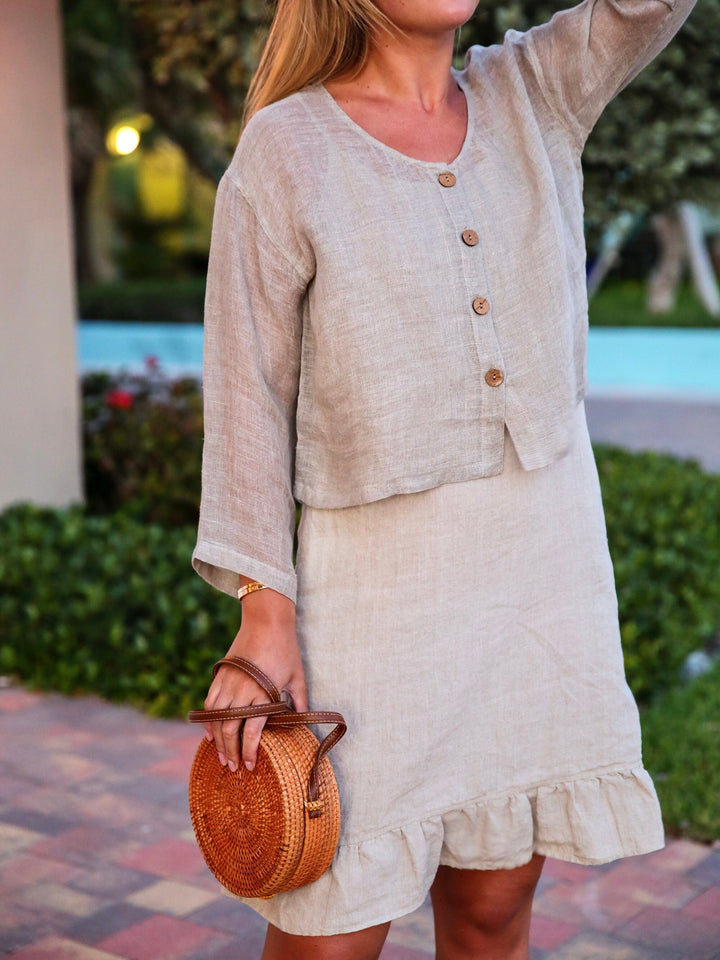 Woman gracefully adorned in a Vikolino Linen Ruffle Dress.