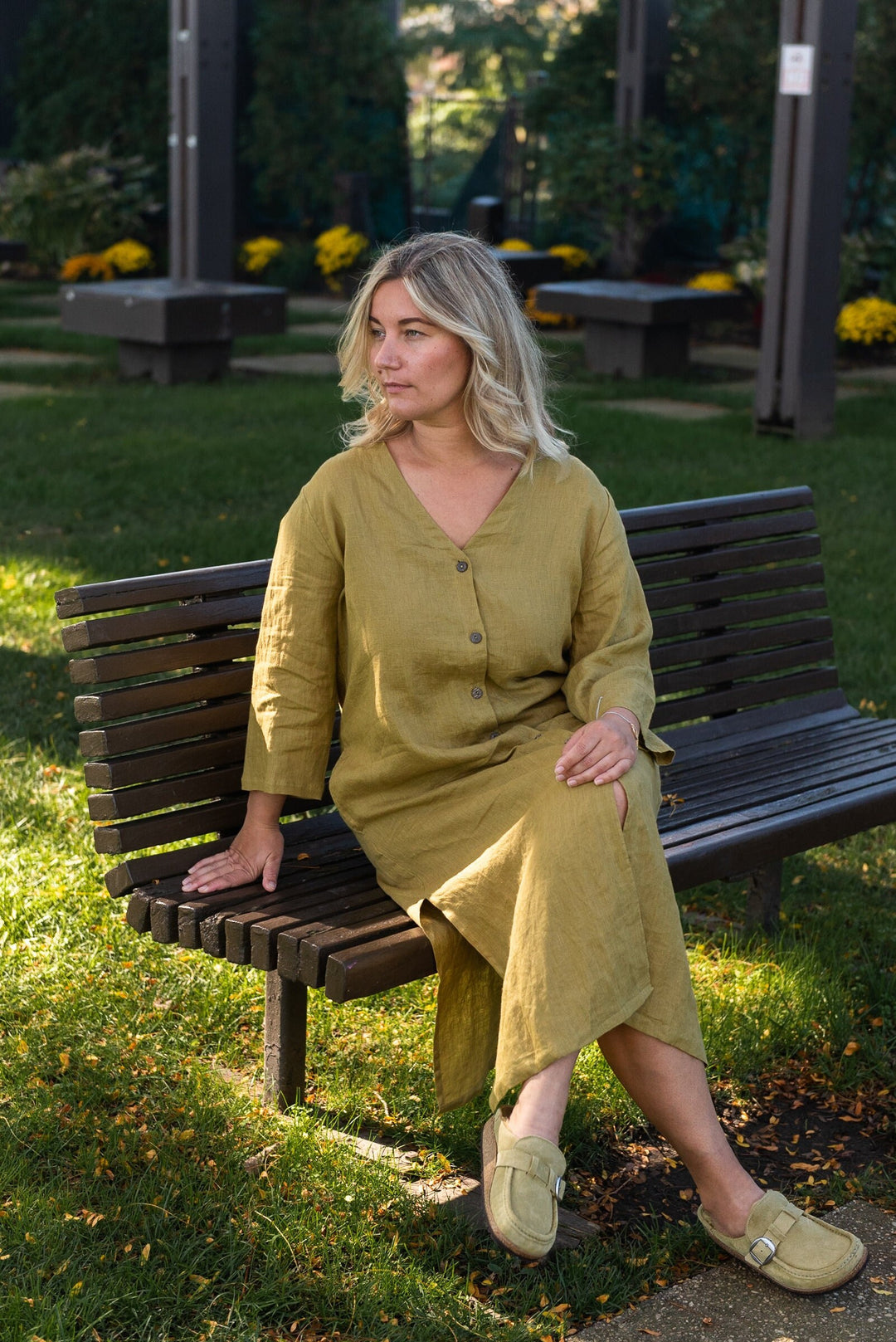 Woman draped in a mustard yellow linen duster, radiating effortless chic.