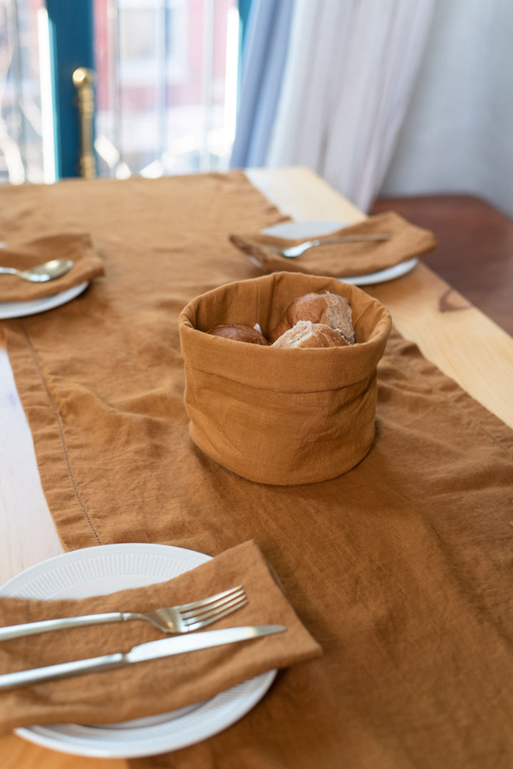 Full-length linen table runner draping over table edge.