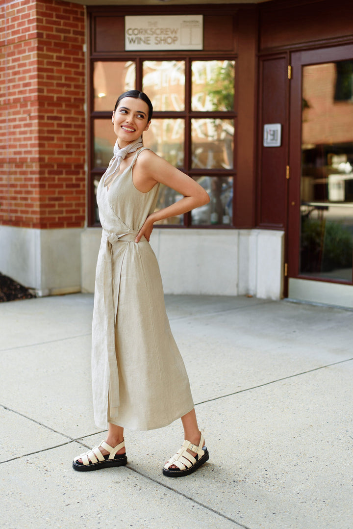 Woman embracing the soft texture of a pre-washed linen wrap dress.