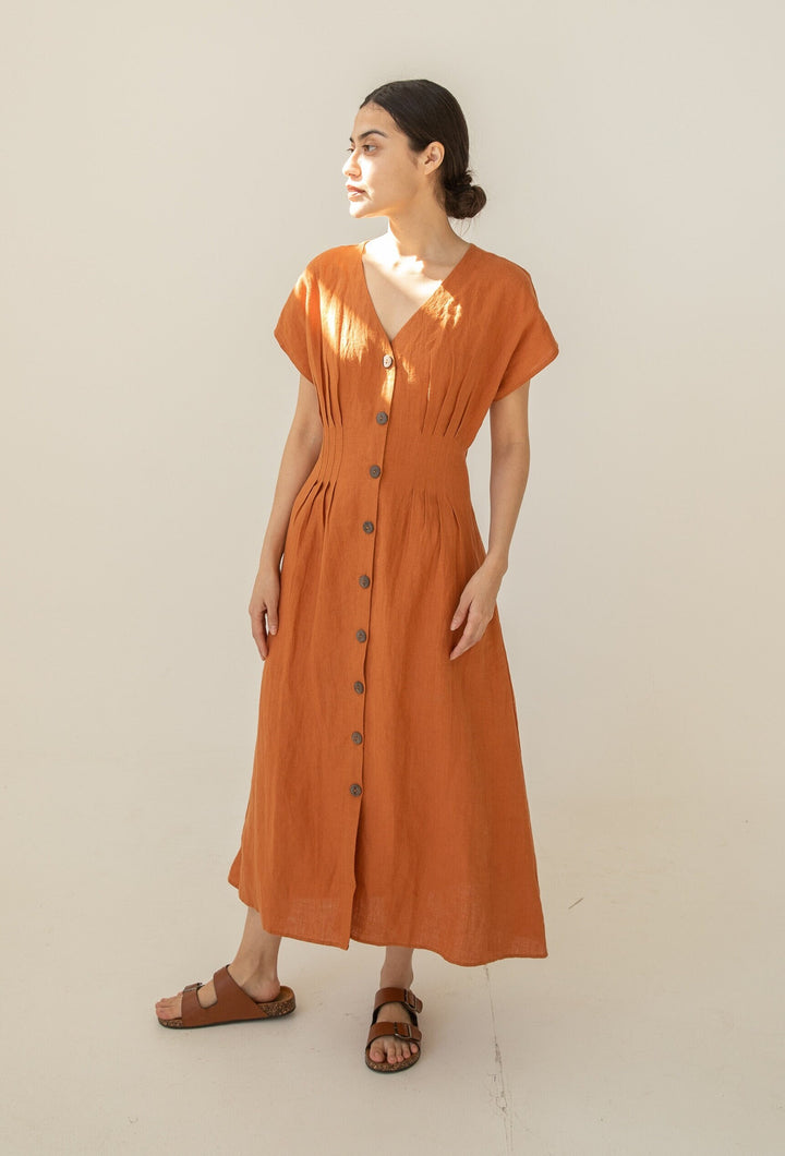 Elegant woman in a rust-colored Linen Charlotte Long Dress.