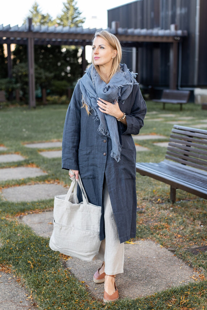 Woman wearing the Linen Renu Long Coat, front view, showcasing its length.