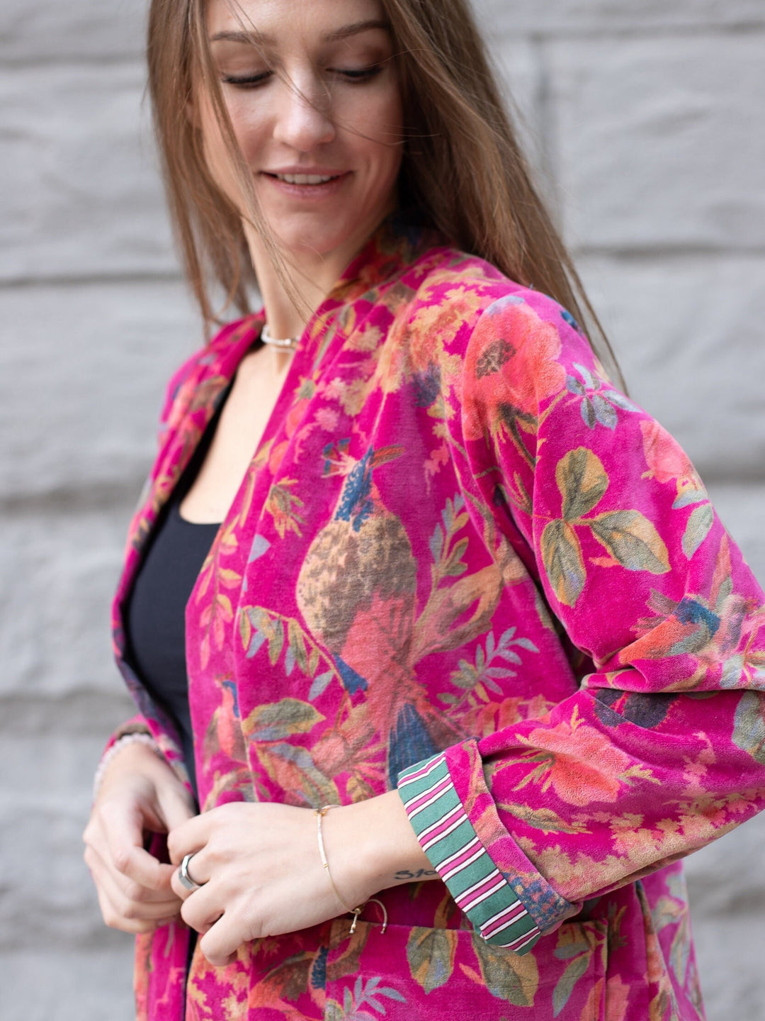 Close-up: Model highlighting vibrant striped lining in Japanese Velvet Kimono Cardigan with open Pink Bird Print Jacket.