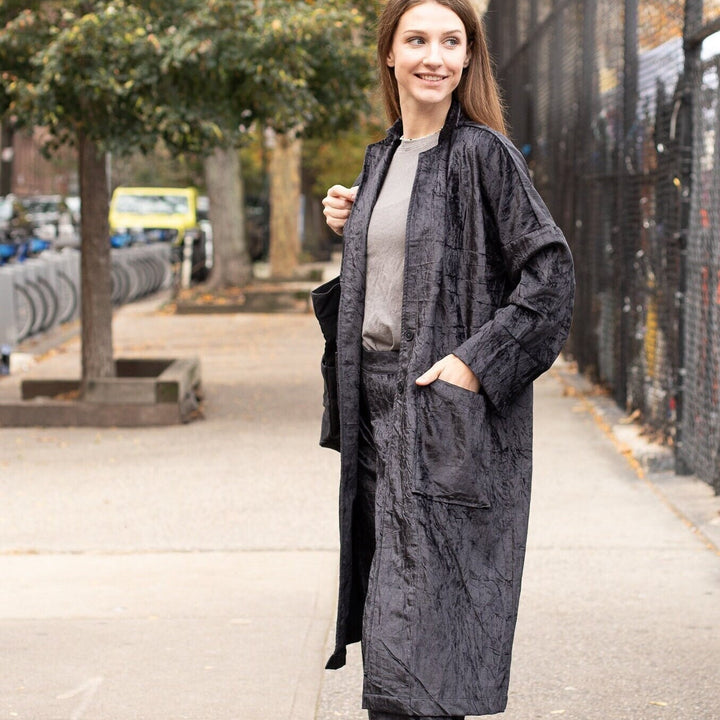 Young woman standing confidently, elegantly showcasing the Black Velvet Long Duster Jacket - Stylish Fall Coat and Velvet Cardigan for Women.